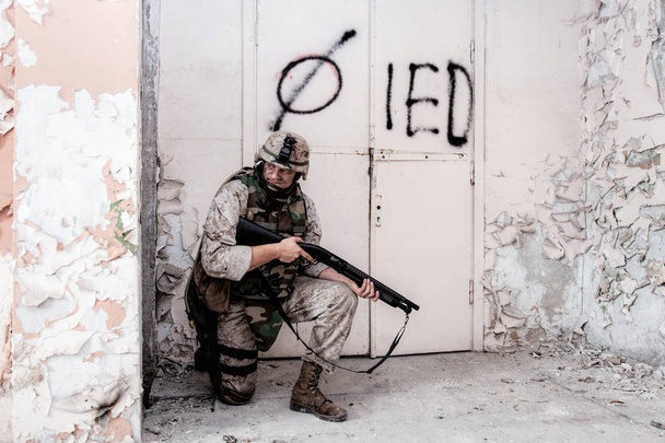 Marine shooter with shotgun take cover behind wall - Photo, Image