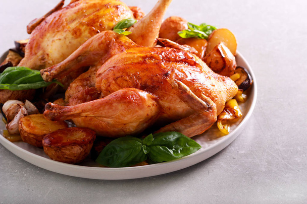 Roast chickens with roast vegetables on plate - 写真・画像