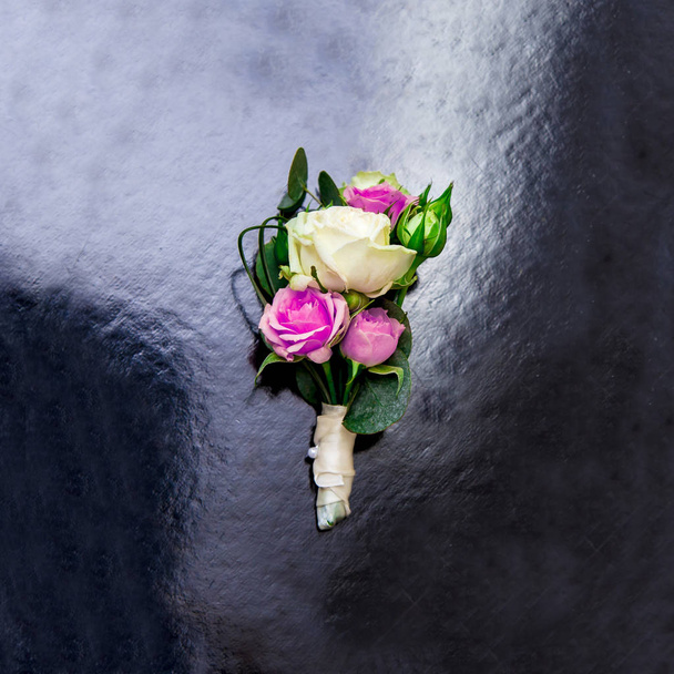 Boutonniere-a rügyek, fehér és rózsaszín rózsa, a fekete fényes felület - Fotó, kép