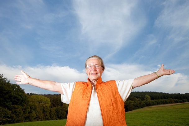 Счастливая пожилая женщина на лугу
 - Фото, изображение