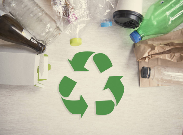 Recycle symbool en plastic, papier, glas op houten tafel achtergrond bovenaanzicht. Eco en slaan de aarde concept. - Foto, afbeelding