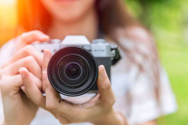 de voorste lens van de close-up van mirrorless camera in vrouw tiener fotograaf - Foto, afbeelding