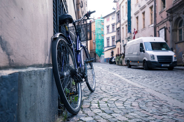 A bike in the old streets as a symbol of eco-friendly transport. Cobblestone pavement in the historic center of Riga, Latvia. - Fotó, kép