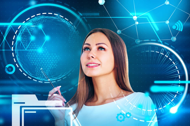 Attractive young woman with fair hair holding a pen, looking up and thinking. Futuristic glowing icons. HUD and infograph. Toned image double exposure mock up Elements of this image furnished by NASA - 写真・画像