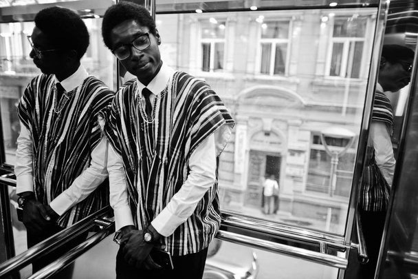 Afrikai férfi hagyományos ruhák és a szemüveg, elavator, vagy a modern lift. - Fotó, kép