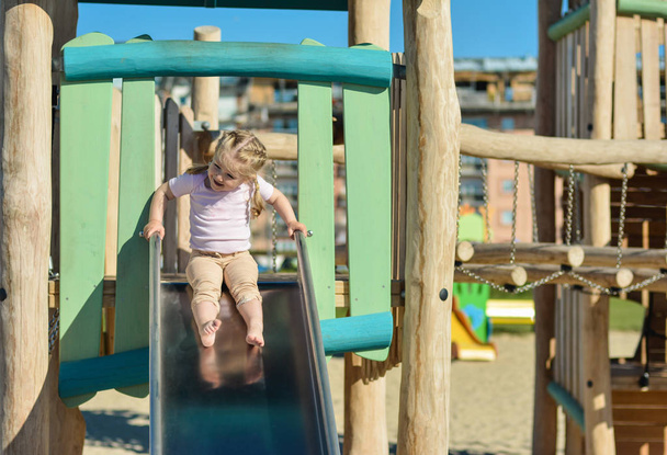 Girl of three years old sliding outdoor Playground - Fotoğraf, Görsel