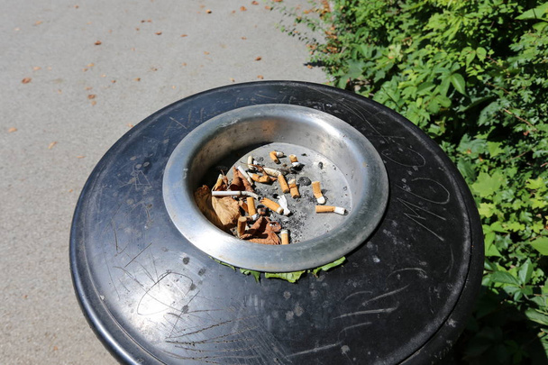 Der Aschenbecher ist ein Gefäß für Zigarettenstummel und Tabakasche, ein häufiges Merkmal des Rauchprozesses.  - Foto, Bild