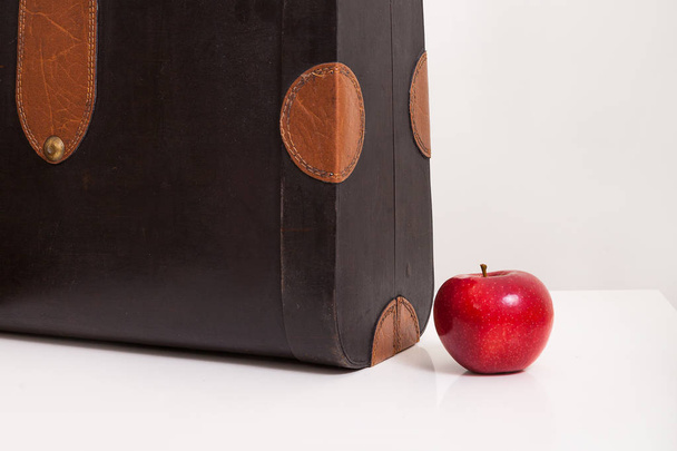 Vintage-Koffer und ein roter Apfel auf weißem Hintergrund. - Foto, Bild