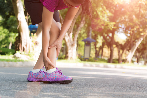 Mujer que sufre de una lesión en el tobillo mientras hace ejercicio. Correr concepto de lesión deportiva
. - Foto, Imagen