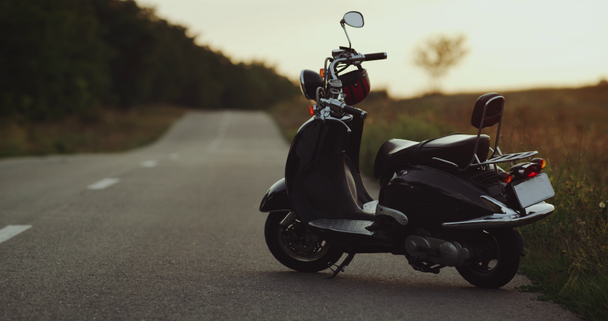 Мотоцикл стоит на дороге с прекрасным видом на закат
 - Кадры, видео
