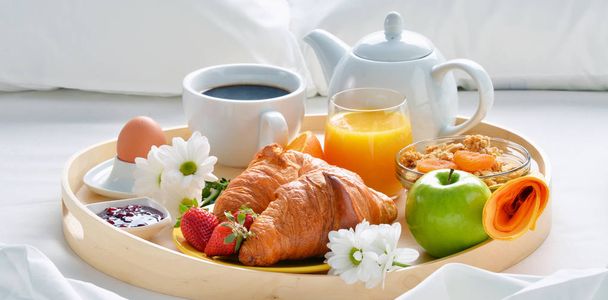 Dienblad van het ontbijt in bed in hotelkamer.  - Foto, afbeelding