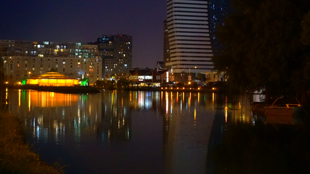 Kawiarnia na wodzie miasta noc, kolorowe światła - Materiał filmowy, wideo