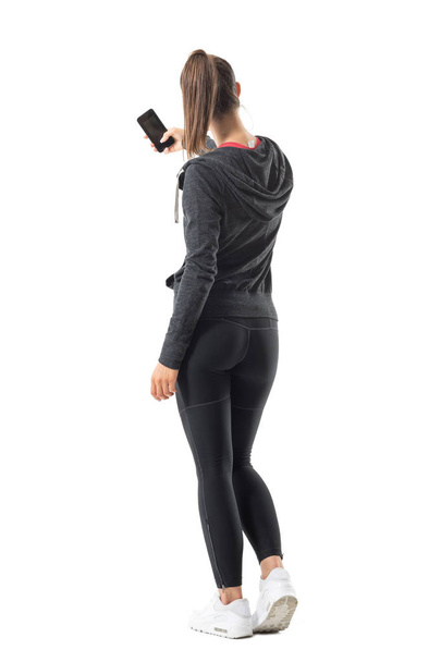 Back view of young sporty fit woman taking photo with smartphone. Full body length portrait isolated on white background. - Zdjęcie, obraz