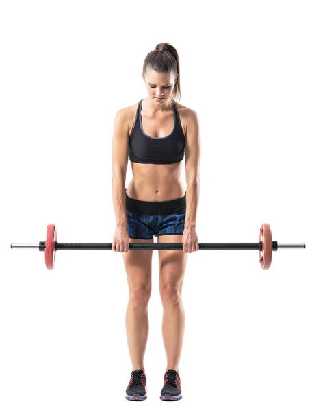 Front view of strong muscular athletic woman doing dead lift exercise with barbell. Full body length portrait isolated on white studio background. - Fotó, kép
