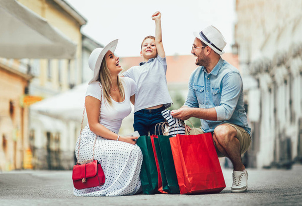 glückliche Familie, die nach dem Einkaufen Spaß im Freien hat - Foto, Bild