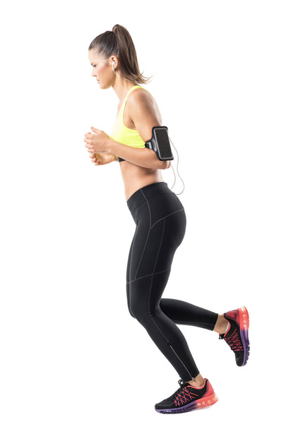 Rilassato giovane donna in forma jogger jogging e guardando giù. Vista laterale. Ritratto a figura intera isolato su sfondo bianco dello studio
 - Foto, immagini