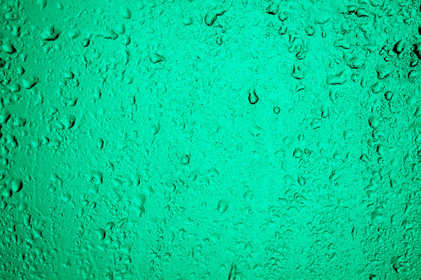 Rainy window. Drops on the glass in turqoise back light - Photo, Image
