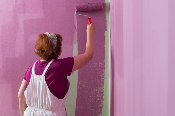 Mujeres de mediana edad pintando pared de pared con rodillo de pintura
 - Foto, imagen