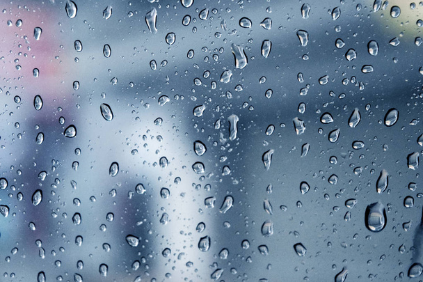 Las caídas de lluvia en la superficie de vidrio en días lluviosos, Las gotas de agua adjuntas en el vidrio, tono de color solitario. - Foto, imagen