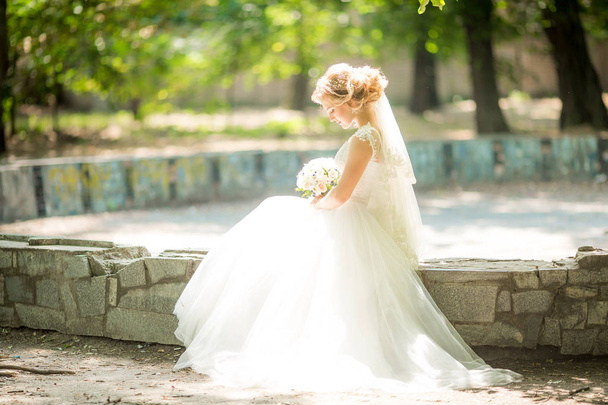 白いウェディング ドレスのポーズに美しい若い花嫁  - 写真・画像