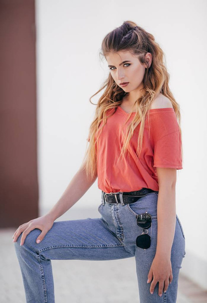 Kaunis nuori nainen farkut ja punainen t-paita poseeraa studiossa
  - Valokuva, kuva