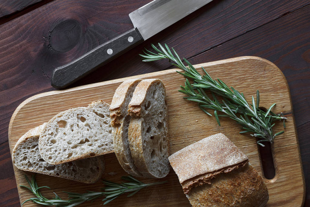 Brot und Rosmarin auf dem Tisch, Draufsicht. Konzept: Lebensmittel - Foto, Bild