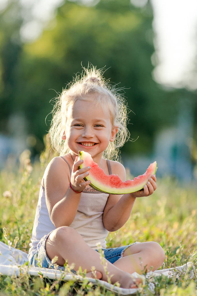 Menina loira comendo melancia no parque de verão. - Foto, Imagem