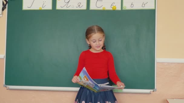 dívka stojící vedle tabule - Záběry, video