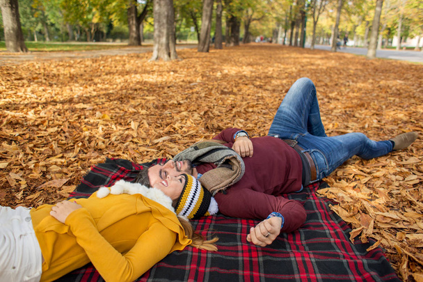 feliz pareja acostada en picknick manta en otoño mientras duerme
 - Foto, Imagen