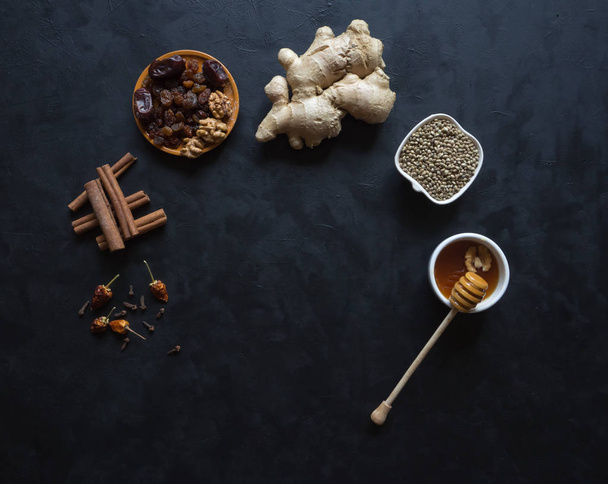 Ingredients for baking using ginger, cinnamon, cloves, dried fruit and hemp seeds. - Photo, Image