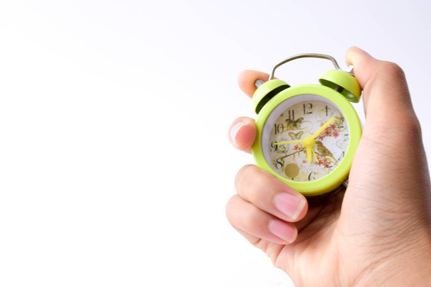 mano con reloj despertador aislado sobre fondo blanco, concepto de gestión del tiempo
. - Foto, imagen