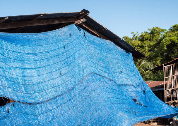 Blu rete ombreggiante copre la terrazza della casa di campagna per proteggere dalla temperatura calda in Thailandia
. - Foto, immagini