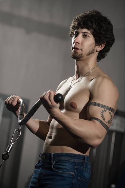 Athletic muscular man training biceps in the gym - Фото, зображення