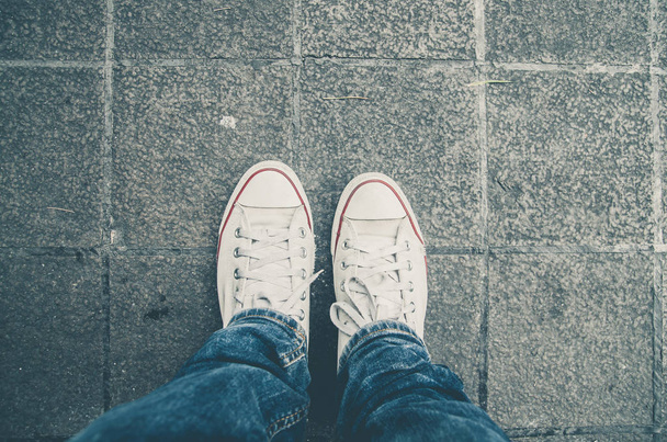 Witte sneakers schoenen lopen op Dirty beton bovenaanzicht, Canvas schoenen lopen op Dirty beton - Foto, afbeelding