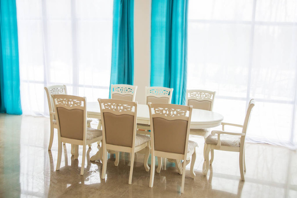 Dining room with wooden table and chairs. Bright interior. Blurred Background. Blue curtains. - Fotografie, Obrázek