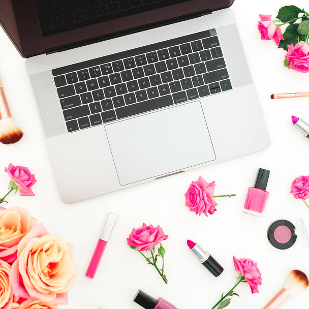 pastelli vaaleanpunainen ruusuja laptop ja naisellinen kosmetiikka eristetty valkoisella pohjalla, ylhäältä
 - Valokuva, kuva