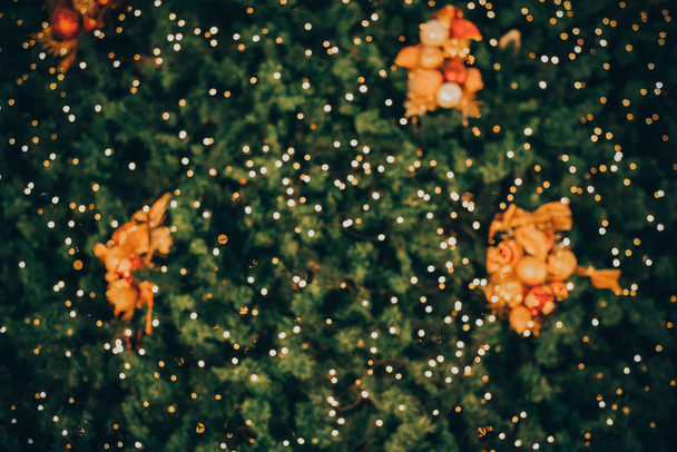 Absztrakt életlenítés háttér vintage karácsonyfa díszítéssel labda - Xmas fa: télen este fél fény bokeh. Vintage színtónus - Fotó, kép