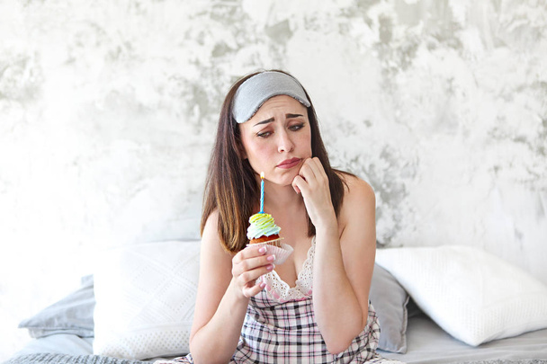 Szomorú, magányos nő a gazdaság cupcake szobájában születésnapi - Fotó, kép