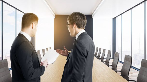 Handsome european businessmen discussing document in modern meeting room interior with sunlight. Teamwork concept. 3D Rendering  - 写真・画像