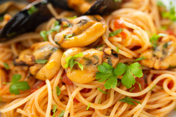 Plato de pasta de espagueti con mejillones y salsa de tomate, comida mediterránea
  - Foto, imagen