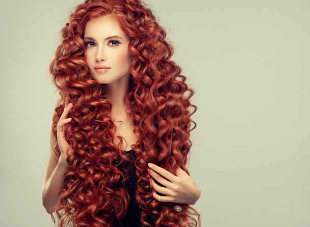 Το όμορφο μοντέλο κορίτσι με τα κόκκινα σγουρά μαλλιά. Νεαρή γυναίκα με σύντομο hairstyle κυματιστό - Φωτογραφία, εικόνα