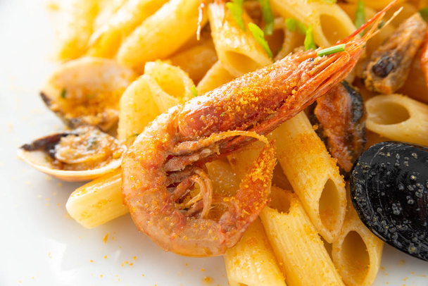 Pokrm z penne allo scoglio, typické italské těstoviny s plody moře a bottargou  - Fotografie, Obrázek