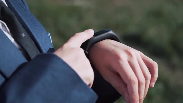 Little cute boy in business suit and use smart watch on the street. Close up - Footage, Video