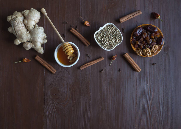 Składniki na stole brązowy do pieczenia przy użyciu miodu, imbir, cynamon, goździki, suszone owoce i konopi nasiona. - Zdjęcie, obraz