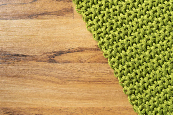 Couverture de laine, vert, tricoté grand fil chunky. Gros plan de la couverture tricotée sur fond en bois
. - Photo, image