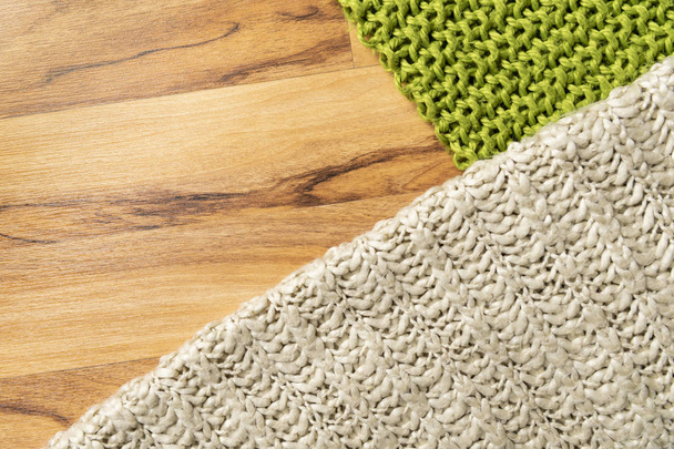 Yün Battaniye, beyaz ve yeşil, büyük tıknaz iplik örme. Ahşap zemin üzerine örme battaniye Close-up. - Fotoğraf, Görsel