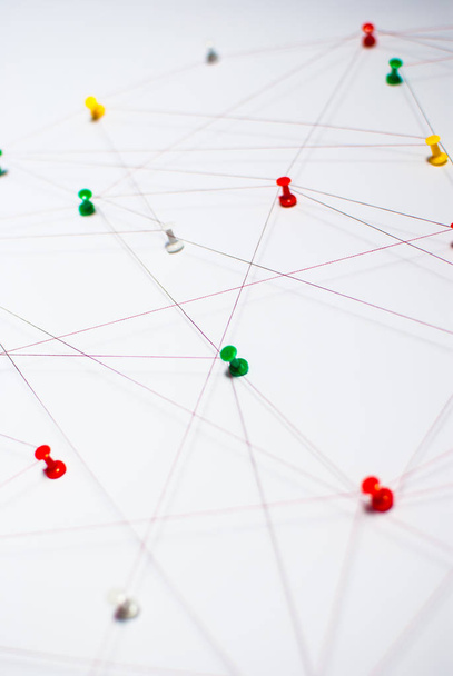 Background. Abstract concept (idea) of network, social media, internet, teamwork,  communication abstract. Colorful push pins linked together by red thread. Isolated. Entities connected. - Photo, Image