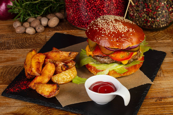 Delizioso hamburger classico con patatine fritte e salsa
 - Foto, immagini