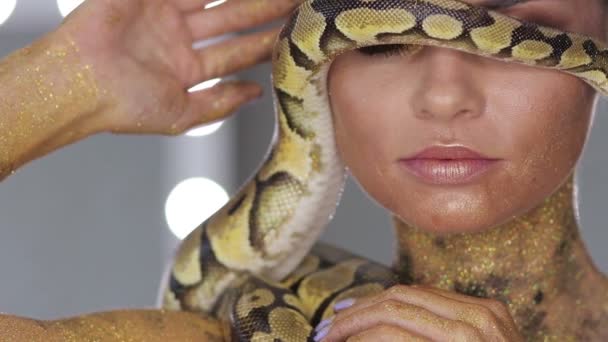 Frau mit Körperkunst hält Schlange - Filmmaterial, Video