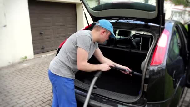 Man hoovering car trunk before a trip - Footage, Video
